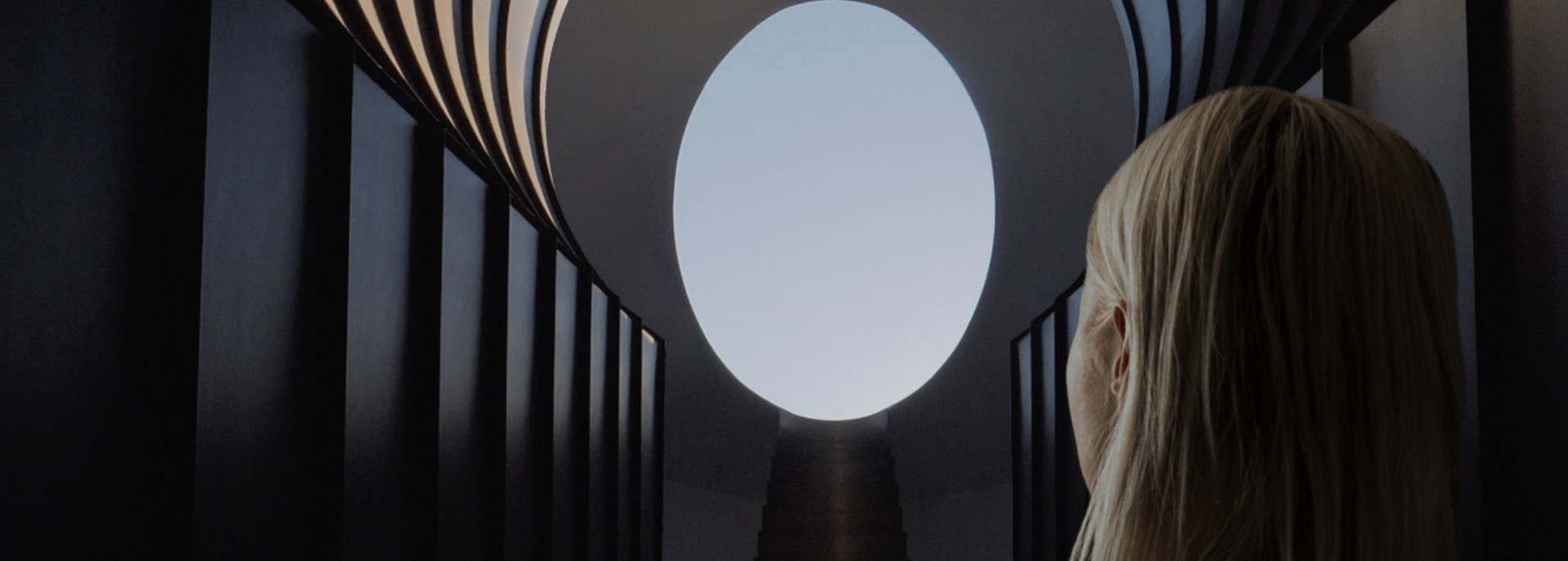 A woman peers at the daylight through an opening